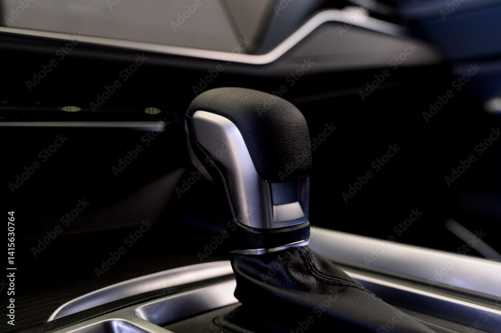 Selector automatic transmission with leather in the interior of a modern expensive car. The background is blurred. Selector automatic transmission with leather in the interior of a modern expensive car. The background is blurred.