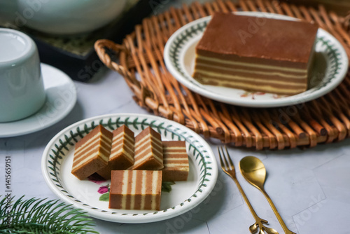 A traditional Indonesian steamed layer cake with alternating vibrant layers, showcasing a soft, moist texture and rich flavors, perfect for festive occasions.