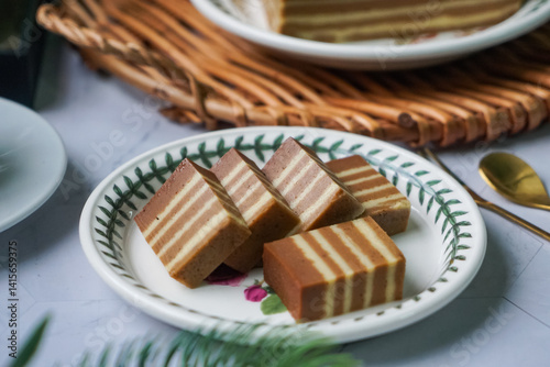 A traditional Indonesian steamed layer cake with alternating vibrant layers, showcasing a soft, moist texture and rich flavors, perfect for festive occasions.