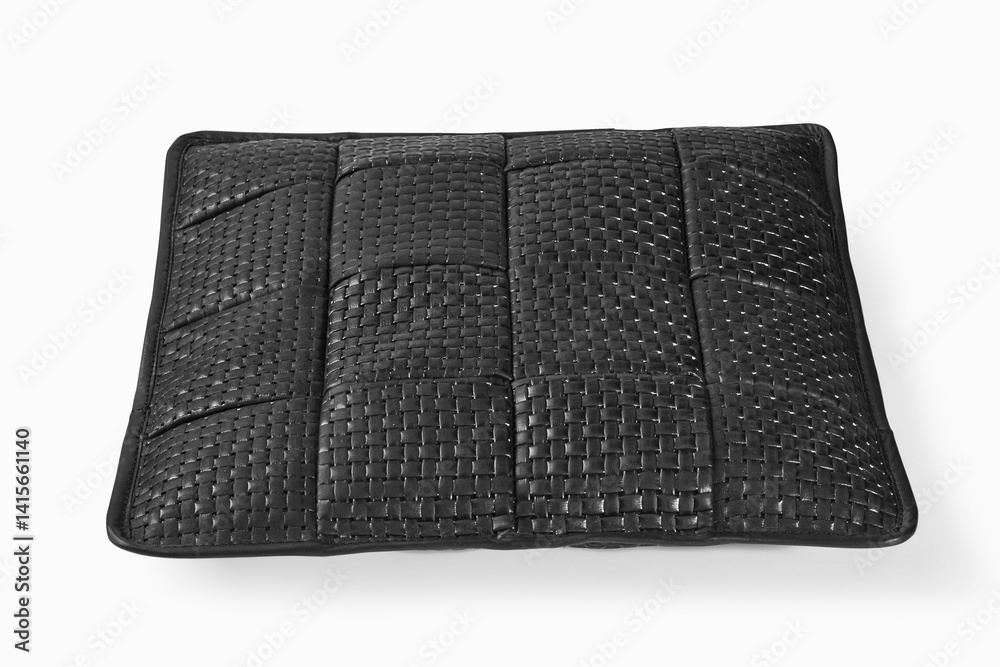 Black leather cushion resting on white background
