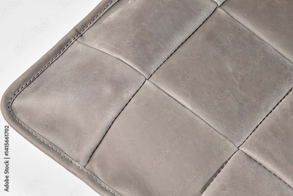 Close up of gray leather cushion showing stitching and texture