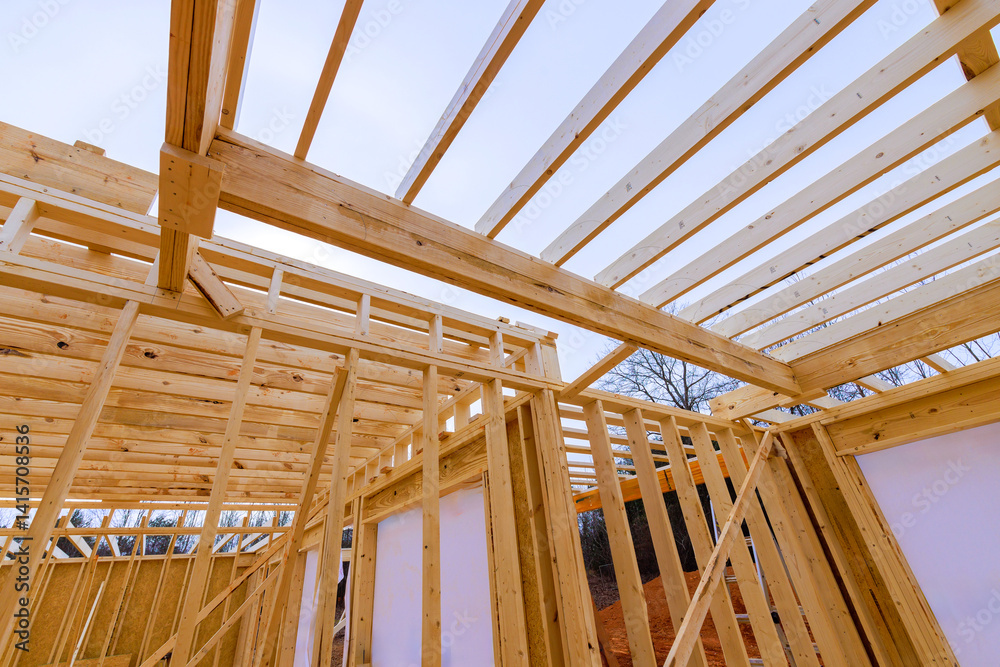 Obraz premium Construction crews are assembling wooden beams for house framed by open