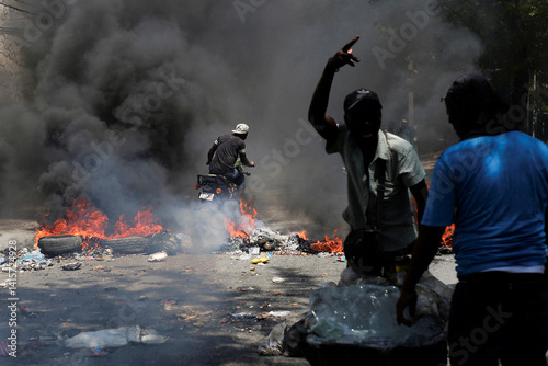 Motorcyclist Rides Past Burning Barricade During Protest in Port-au-Prince, Haiti
