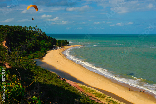 Fototapeta Naklejka Na Ścianę i Meble -  skydive, yellow paraglider flying over beach.