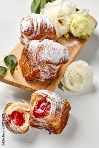 Obraz na płótnie Delicious puff pastry cruffins with strawberry filling and icing sugar on wooden board w salonie