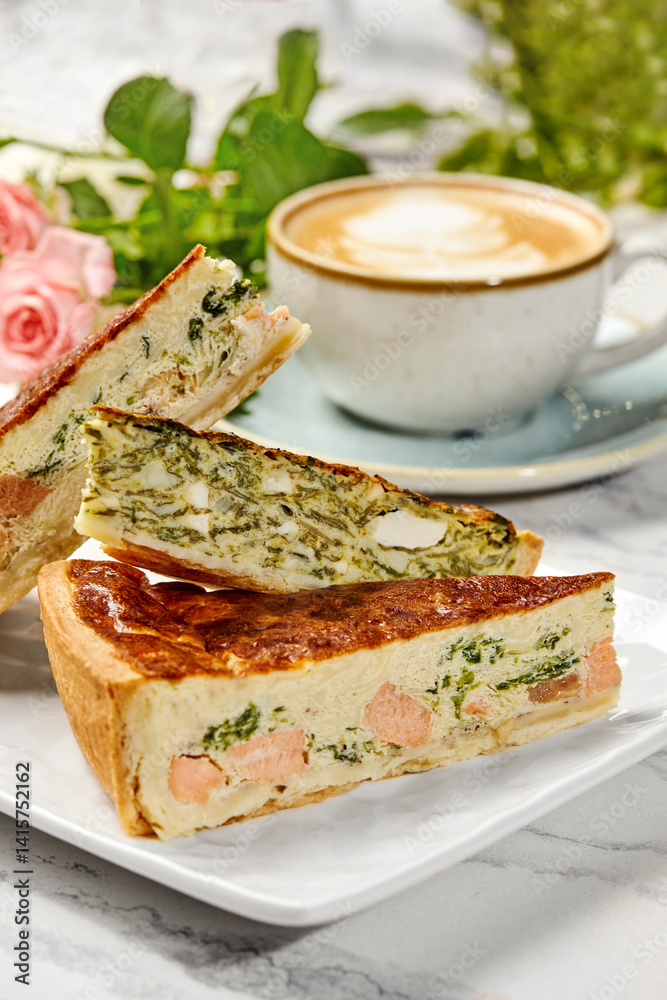 Delicious homemade quiche with salmon and spinach filling enjoyed with cappuccino