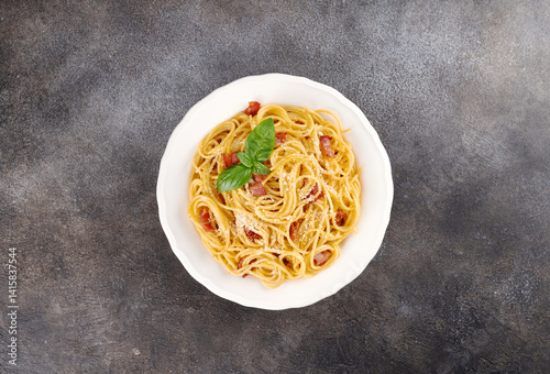 Italian pasta carbonara with bacon, cheese, eggs, garlic on dark background. Top view.