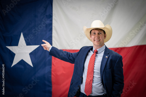 Obraz na plátně Smiling Texas Businessman Politician Wearing Cowboy Hat and Suit Pointing At Lar