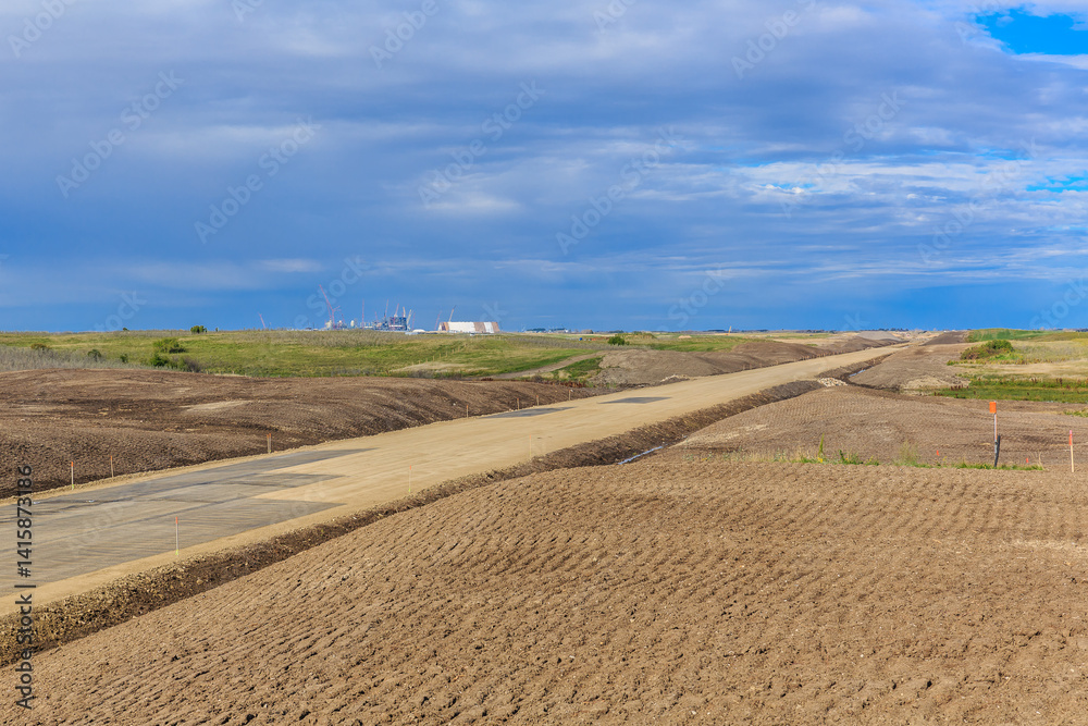 Road is shown in the distance with a cloudy sky above Road is shown in the distance with a cloudy sky above