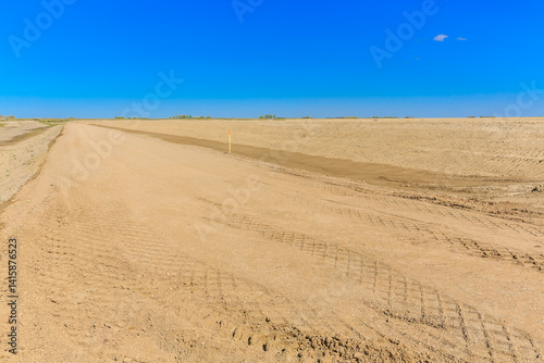 Dry, dusty road with a blue sky in the background