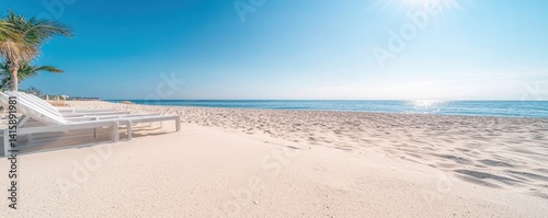 A serene beach scene featuring white sand, inviting lounge chairs, and a clear blue sky reflecting the sun