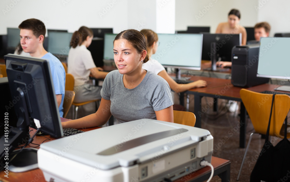 Fototapeta premium Portrait of young female student studying in university computer class