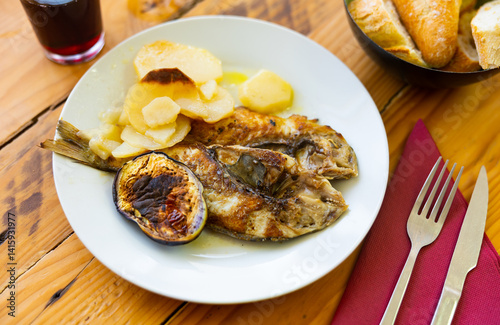 Healthy and low-calorie dish of fried dorado fish, complemented by side dish of boiled and baked vegetables - potato and eggplant