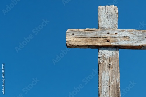 A blue sky full of life serves as a striking contrast to a worn wooden cross