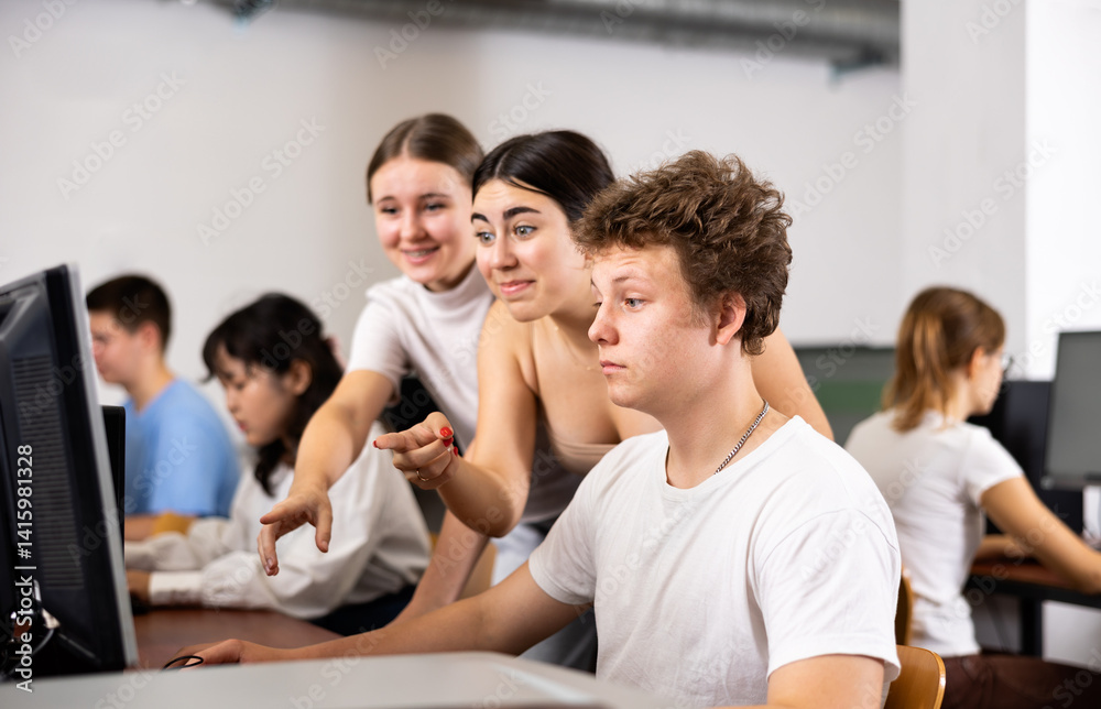 Positive young boy and girls using personal computer together. Cheerful teenagers in computer class. Positive young boy and girls using personal computer together. Cheerful teenagers in computer class.