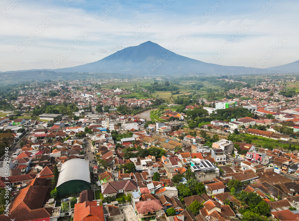 Aerial view of the residential area and its surroundings of Garut city with Mount Cikuray in the background and the Cimanuk River also visible. Garut is a district in West Java, Indonesia.