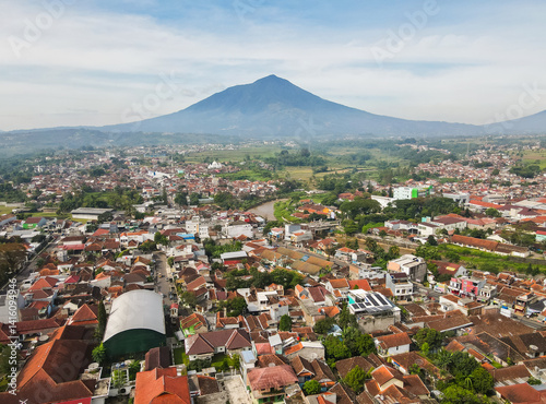 Obraz na płótnie Aerial view of the residential area and its surroundings of Garut city with Mount Cikuray in the background and the Cimanuk River also visible. Garut is a district in West Java, Indonesia. w salonie
