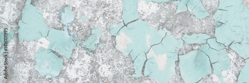 Peeling paint on the wall. Old concrete wall with cracked flaking paint. Weathered rough painted surface with patterns of cracks and peeling. Grunge texture for background and design. High resolution.