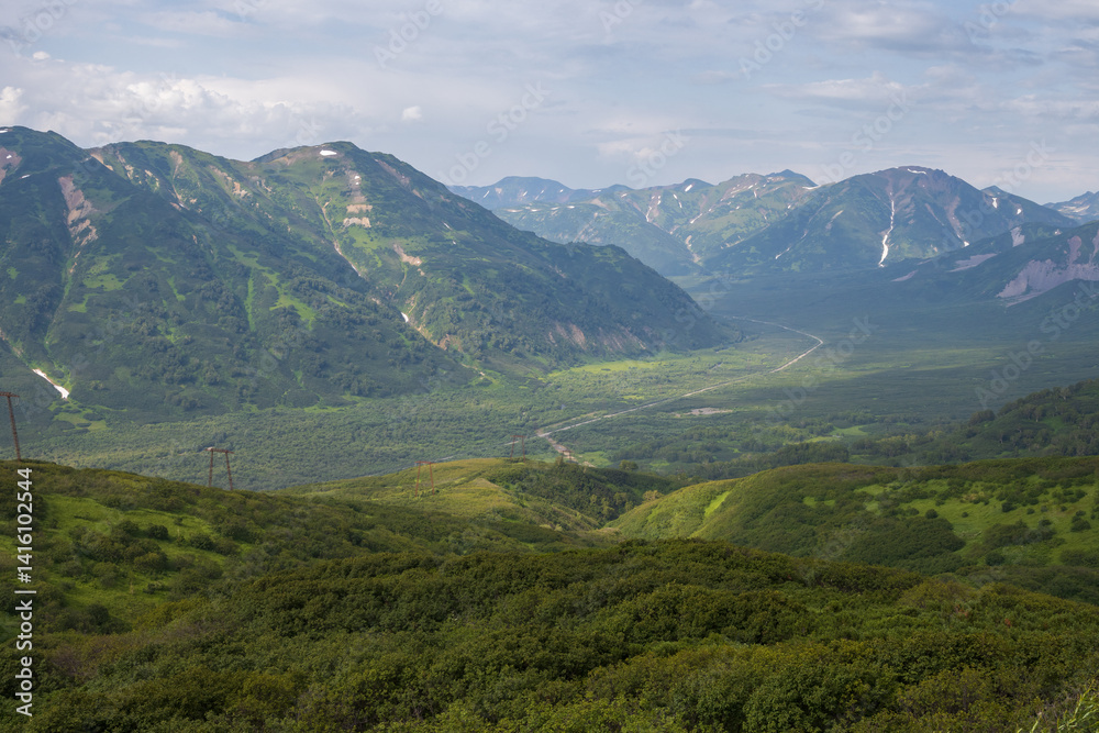 Summer mountain landscape. View from the mountains to the valley. Travel, tourism and hiking on the Kamchatka Peninsula. Beautiful nature of Siberia and the Russian Far East. Kamchatka Krai, Russia.
