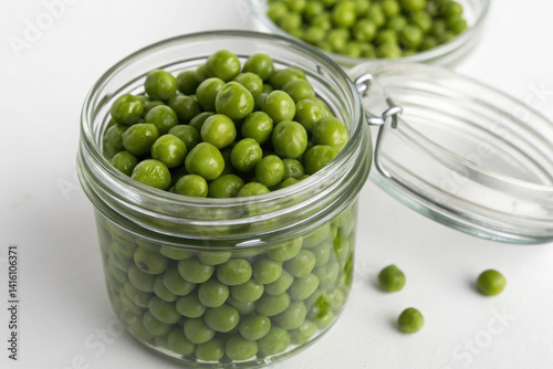 A jar of green peas is sitting on a white table