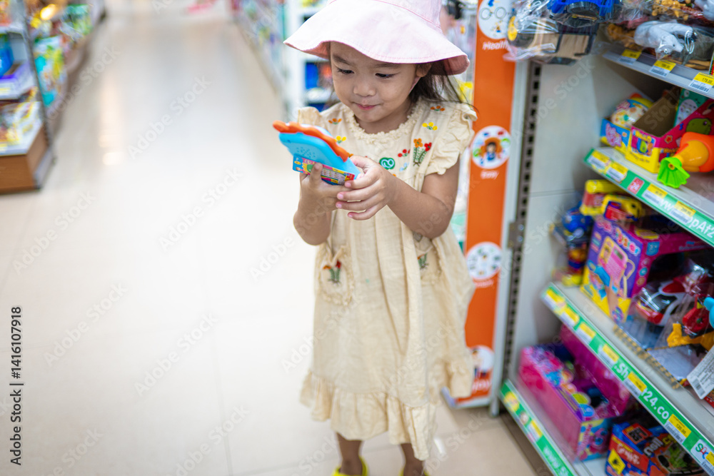 Little girl enjoy shopping toy on shelf in supermarket