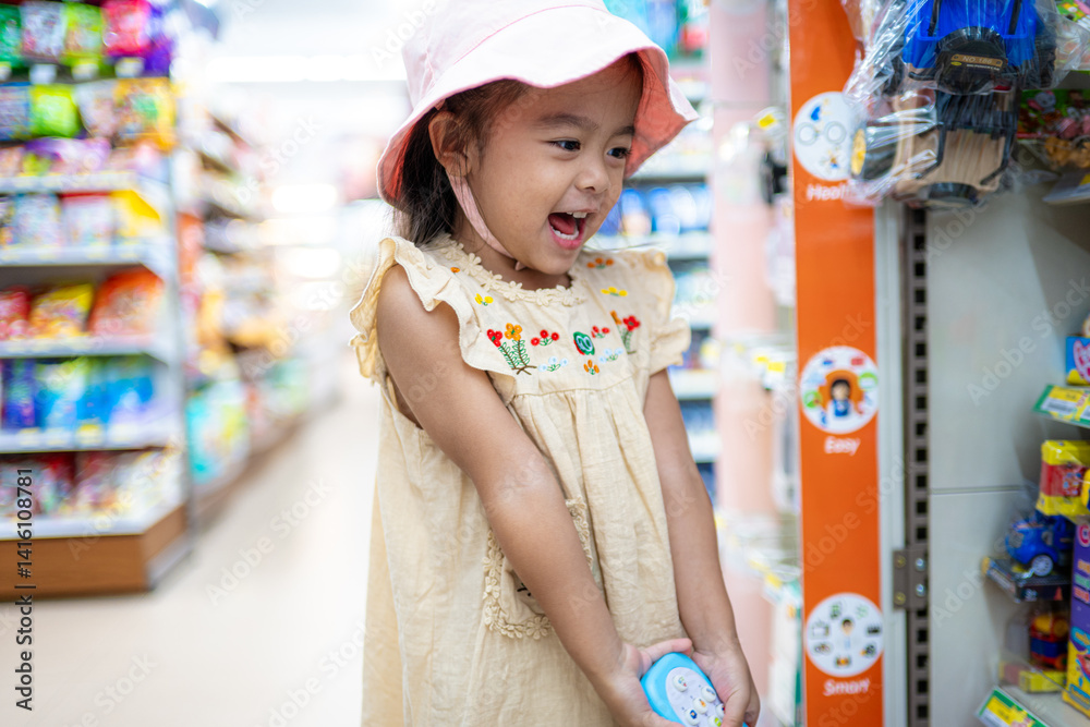 Little girl enjoy shopping toy on shelf in supermarket