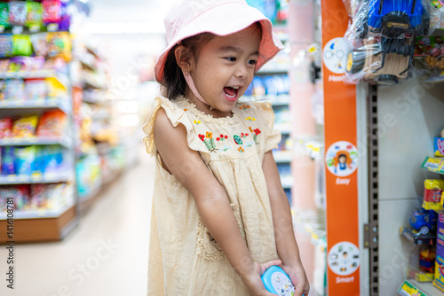 Obraz na płótnie Little girl enjoy shopping toy on shelf in supermarket w salonie