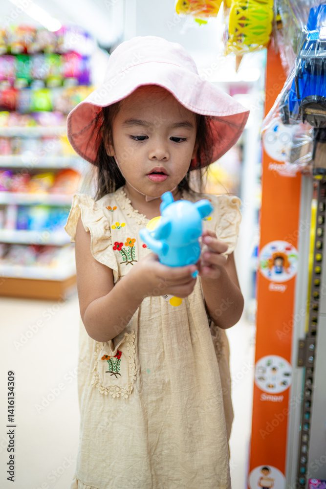 Little girl enjoy shopping toy on shelf in supermarket