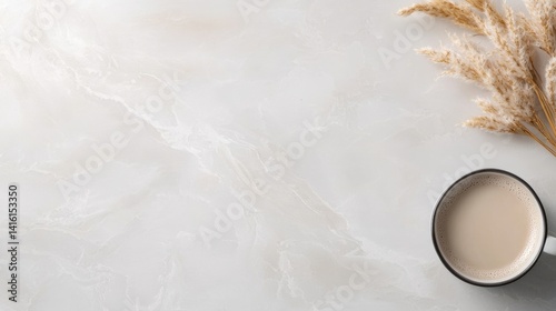 Simple, neutral, elegant, and modern workspace.  A cup of coffee and pampas grass on a light marble surface