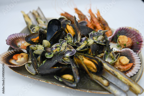 Plato de mariscos a la parrilla compuesto por almejas, camarones, cangrejos, mejillones, vieiras, navajas y langosta.