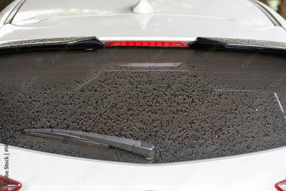 Rear window hatchback dirty car rear view on a dusty glass. Dirty and dusty rear window of a white or gray car.