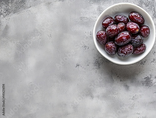 Ripe dates in a white bowl on a grey background, close-up view. Ramadan food concept with copy space for text or design. Fresh date fruits. Stock photo contest winner, high resolution, high detail, na