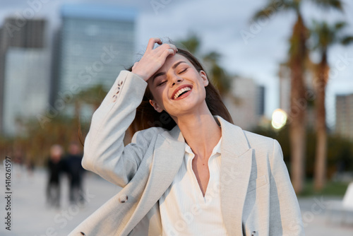 Obraz na płótnie cheerful woman in business casual outfit enjoying urban outdoor setting with joyful smile and relaxed pose in modern city environment w salonie