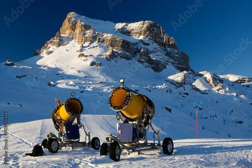 Two snow cannons on a ski slope in the alps, Dolomites, Italy photo