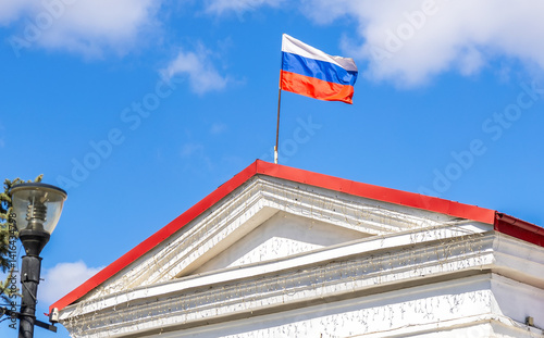 The Russian national flag on the roof of the building photo