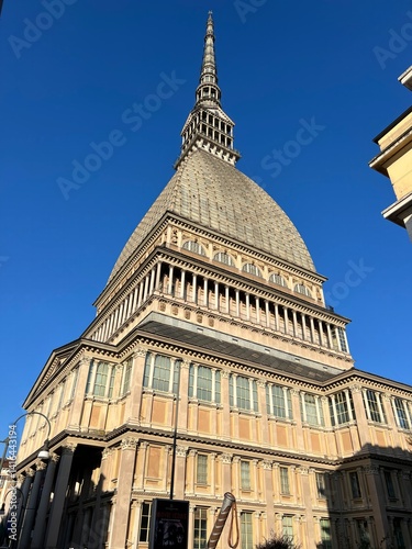 The Iconic Architectural Landmark: The Mole Antonelliana, an architectural marvel, stands tall against a vibrant blue sky, offering a stunning visual of its unique design and historical significance.