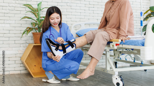 Obraz na płótnie Asian orthopedics physiotherapist nurse help old woman wearing ankle brace injury protection boot walking cast on patient leg in hospital rehabilitation supporting care therapy center healthy wellness w salonie