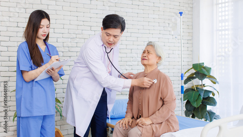 Obraz na płótnie Asian senior woman sit on bed while consulting with doctor and caring nurse checking in hospital, Healthcare elderly patient and medical professional support muscle injury consultation wellness being. w salonie