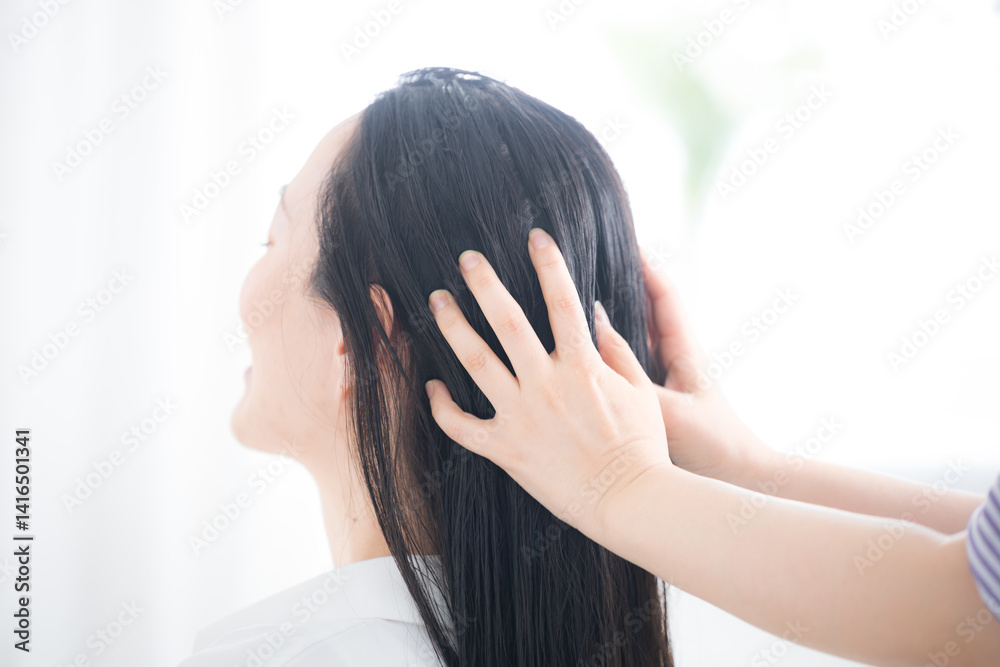 Fototapeta premium 髪のケアやヘッドスパなどをする女性 オイルやトリートメントをする