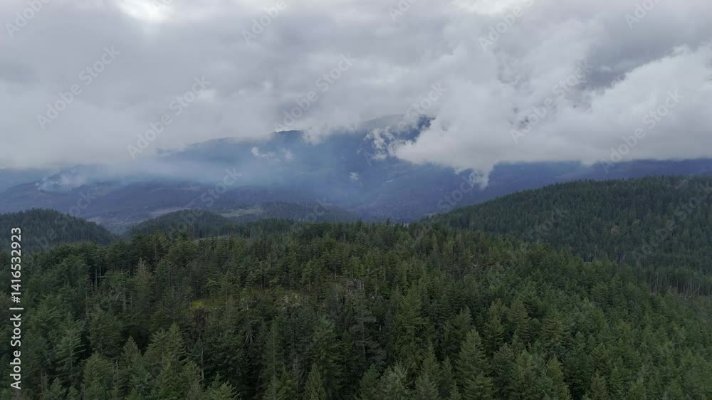 Aerial View of Forests, Hills, and Mountains Under Cloudy Sky in British Columbia, Canada Aerial View of Forests, Hills, and Mountains Under Cloudy Sky in British Columbia, Canada