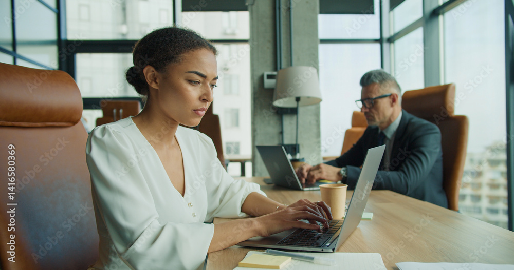 Fototapeta premium Focused businesswoman typing on laptop in office