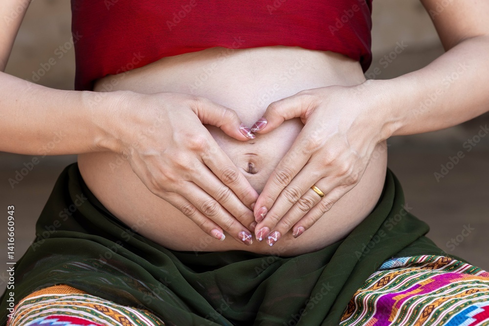 Pregnant asian woman hands making heart shape with hands enjoying pregnancy, Pregnant asian woman showing heart sign maternity love new life, Pregnant asian woman hands touching big belly.