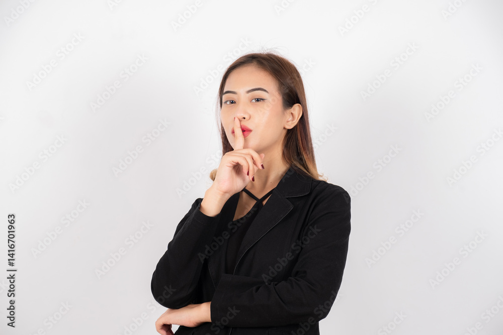 Businesswoman in black blazer making shushing gesture, isolated on white background Businesswoman in black blazer making shushing gesture, isolated on white background