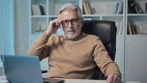 Professional's Contemplation: A distinguished professional, seated at his desk, gazes intently, as though lost in contemplation.