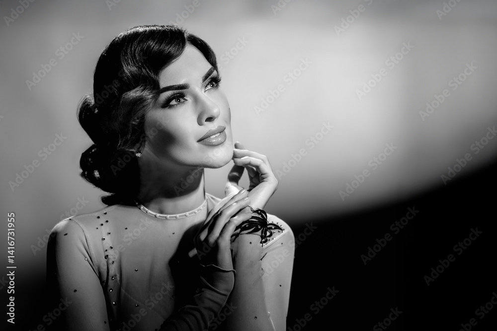 Obraz premium Monochrome styled photo of beautiful young fashionable lady posing. Girl in black and white retro portrait with Harcourt-style lighting and elegant wavy hairstyle