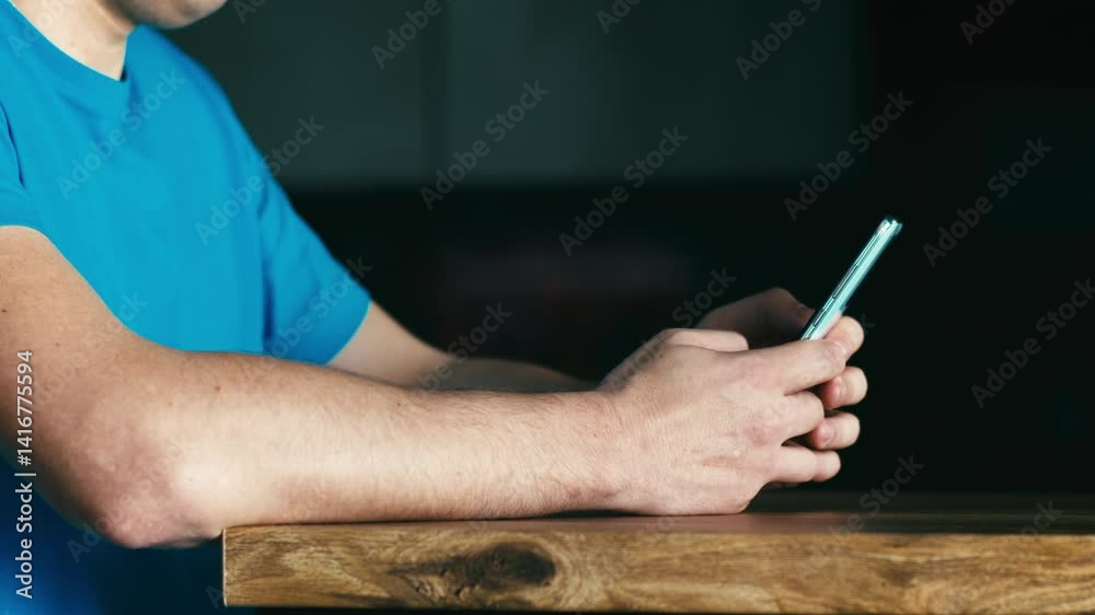custom made wallpaper toronto digitalClose-up of a young man's hands, sitting at a desk and holding a mobile phone, writing a message in a web chat room, reading the news. A millennial man works on the Internet using a smartphone