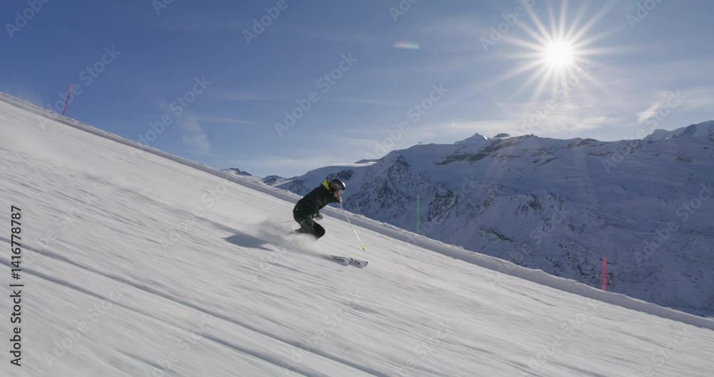 Skiing in Zermatt under the Matterhorn during a blue bird day and perfect slopes. High performance carving on skis.