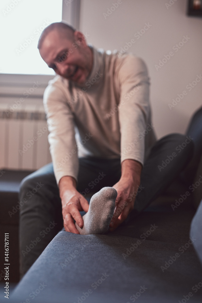 Man with ankle and foot pain at home.