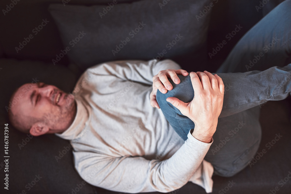 Man with painful knee and leg injury at home.