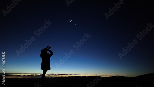 Obraz na płótnie Amateur astronomer looking at the evening skies, observing planets, stars, Moon and other celestial objects with binoculars. w salonie